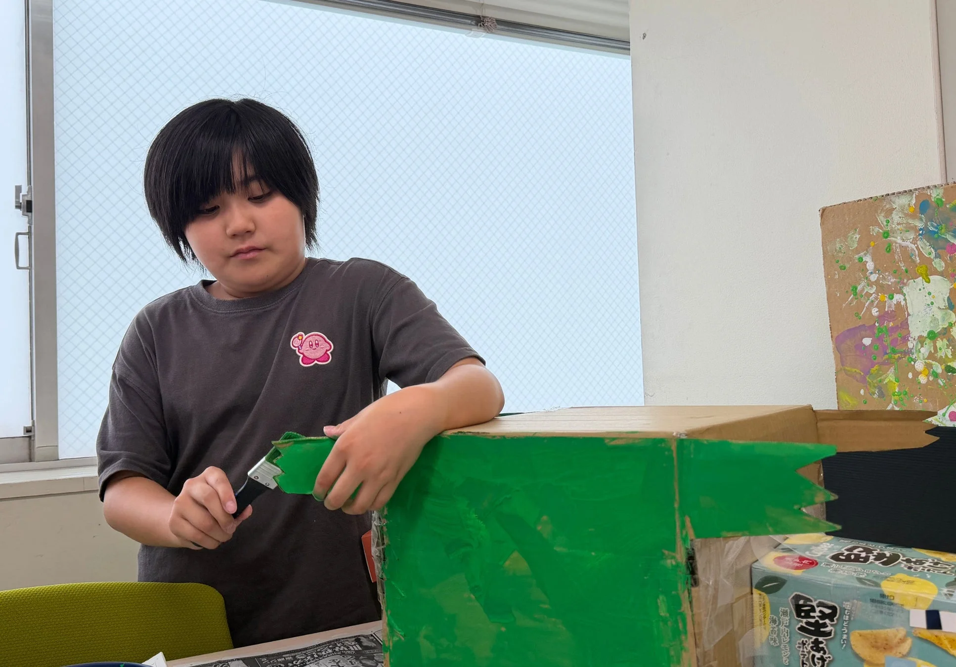 絵の具で段ボールを塗る子供