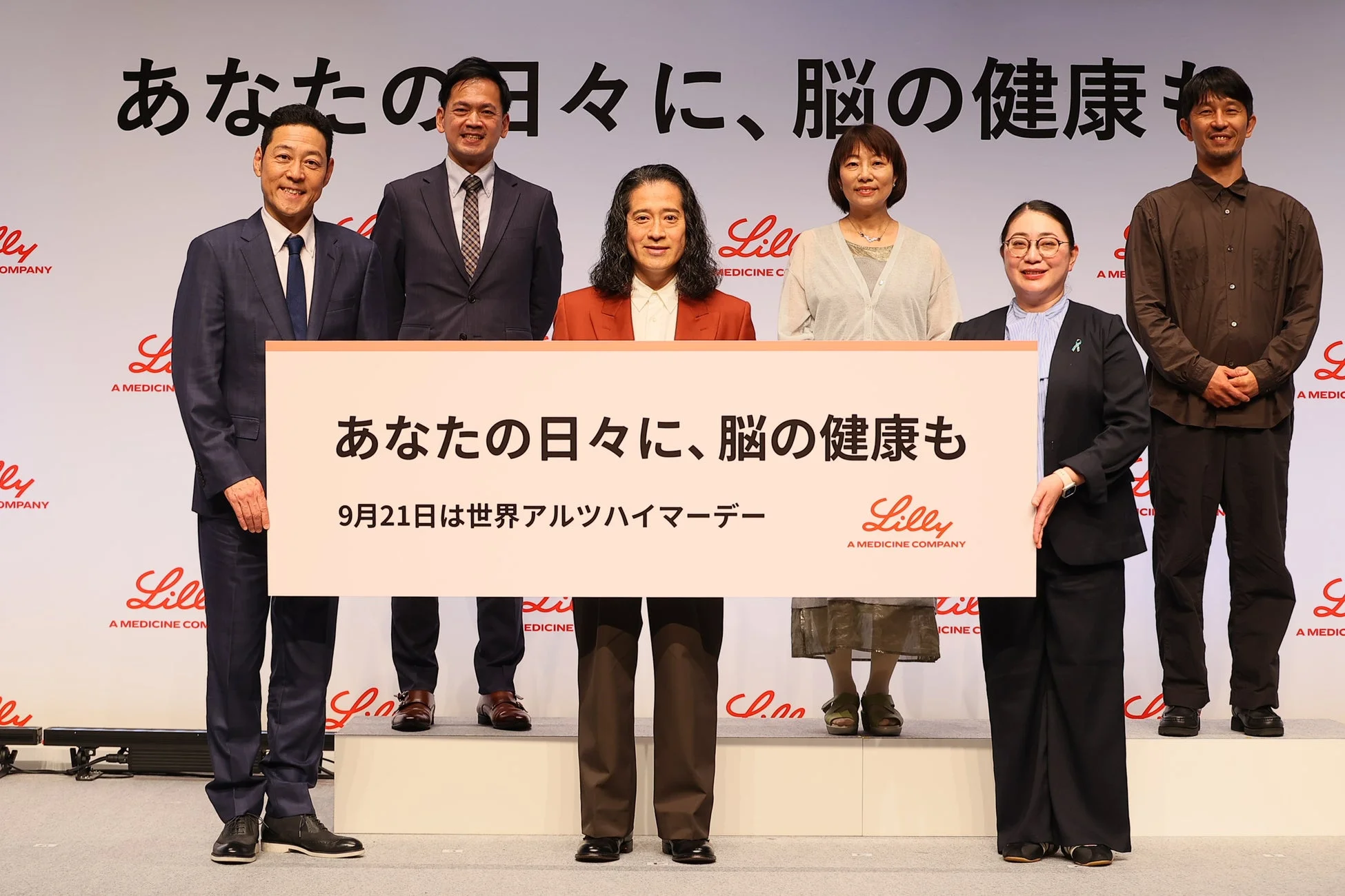 発表会でパネルを掲げる登壇者たち